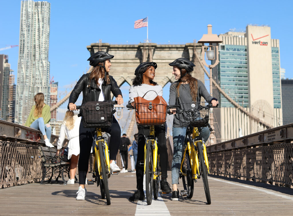 Three friends riding bikes on the Brooklyn Bridge
